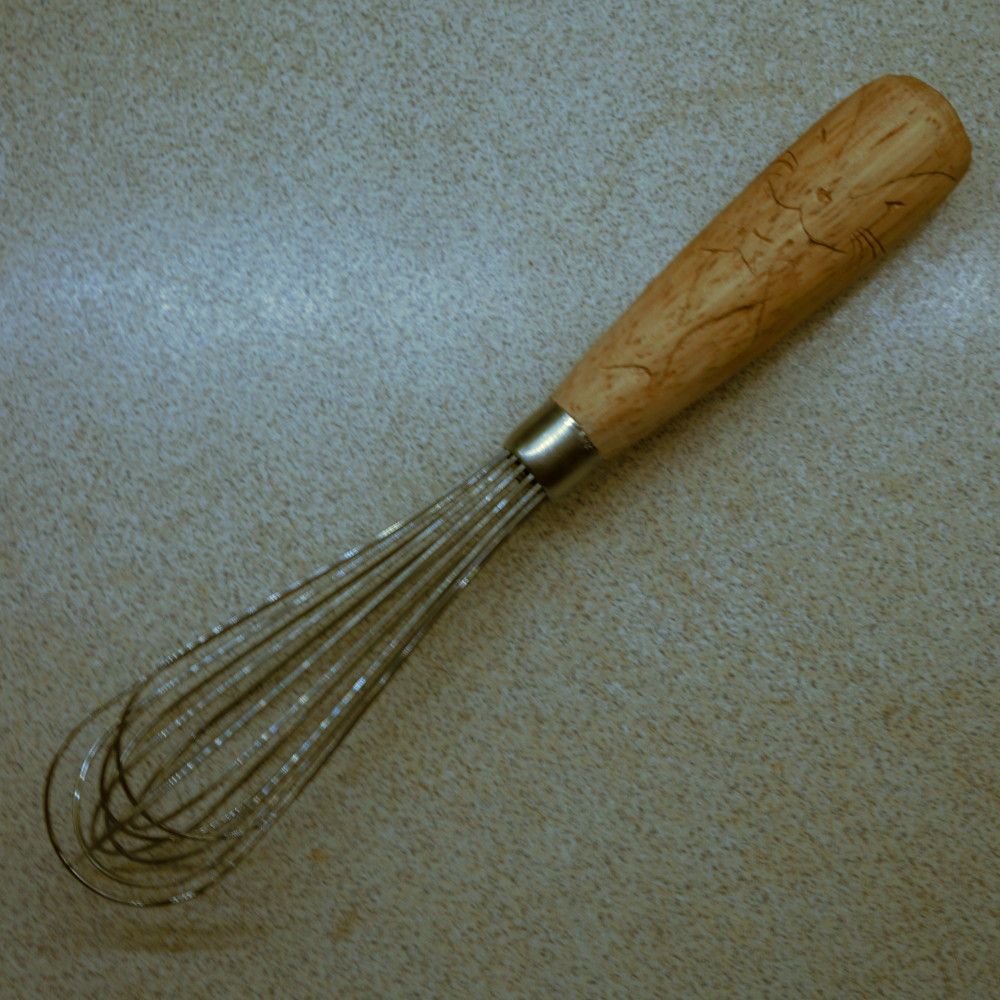 Wooden handled whisk with an otter eating a fish carved in relief images